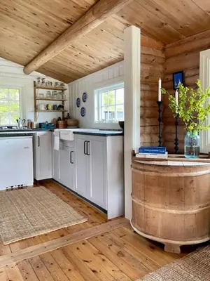 a kitchen with white cabinets and a wooden ceiling at Log Cabin With Views Of Rondane Mountains in Folldal