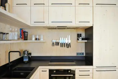 a kitchen with white cabinets and a black counter top at Modern Family Cabin With Trysil Mountain Views in Trysil
