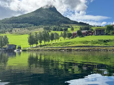 a body of water with a mountain in the background at Living in a Nikolai Astrup motif 96m2 in Vassenden