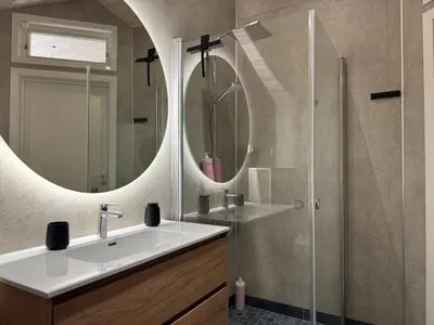 a bathroom with a sink and a shower with mirrors at Living in a Nikolai Astrup motif 96m2 in Vassenden