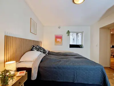 a bedroom with a large bed with a blue blanket at Prime location amazing king bed colorful oasis in Bergen