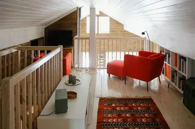 a living room with a red chair and a table at Modern Family Cabin With Views Of Spåtind in Etnedal