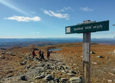 a group of people standing on a mountain with a sign at Modern Family Cabin With Views Of Spåtind in Etnedal