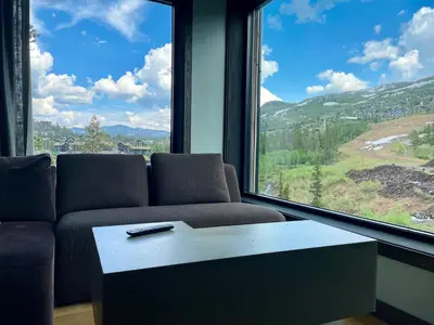 a living room with a couch and a large window at Gausta Sportell in Gaustablikk
