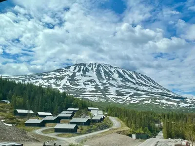 a snow covered mountain with houses and a road at Gausta Sportell in Gaustablikk