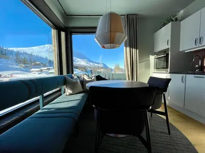 a living room with a blue couch and a table at Gausta Sportell in Gaustablikk