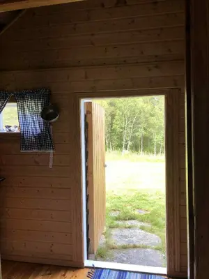 an open door in a wooden room with a window at Stall Rygg Mountain Cottage, Gloppen