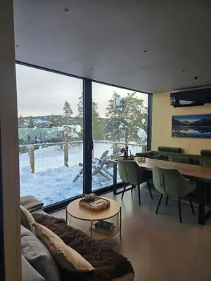 a living room with a large window and a table and chairs at Modern Cabin At Blefjell in Svene
