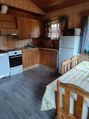 a kitchen with wooden cabinets and white appliances at Stavn gård og hytter- 8 minutter til Bjørneparken in Flå