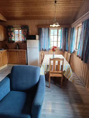 a kitchen with a table and a blue couch in a room at Stavn gård og hytter- 8 minutter til Bjørneparken in Flå