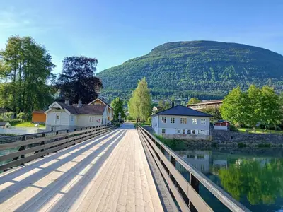 a bridge over a river with a mountain in the background at Stryn Norway in Stryn