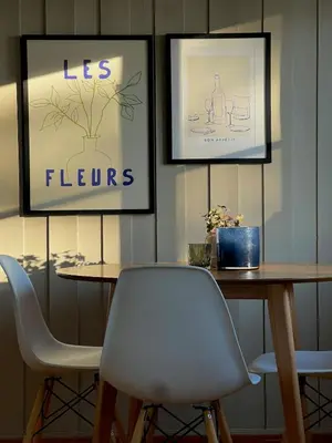 a table with two chairs and two pictures on the wall at Leilighet nær Color Line i Larvik in Lii