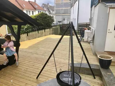 a woman sitting on a deck with a swing at Kozy apartment near Bergen city center with free parking and Wifi in Bergen