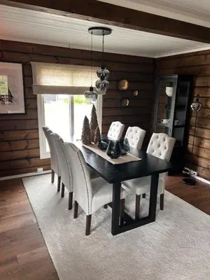 a dining room with a black table and white chairs at Sjarmerende tømmerhytte på Bjorli in Lii