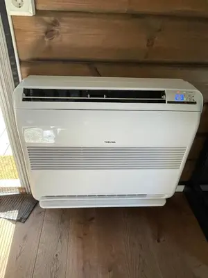 a air conditioner is sitting on a floor at Sjarmerende tømmerhytte på Bjorli in Lii