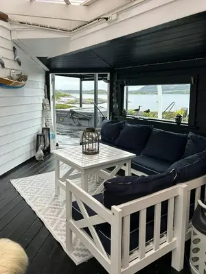 a living room with a couch and a table at Cabin With Sea Views In Mjømna