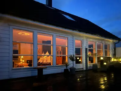 a house with a window with a sail boat in it at Cabin With Sea Views In Mjømna
