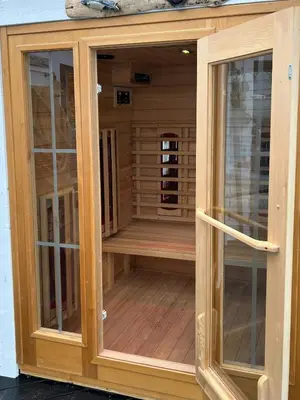 a wooden enclosure with glass doors on a deck at Cabin With Sea Views In Mjømna