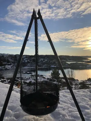 a swing in the snow with a fire in it at Cabin With Sea Views In Mjømna