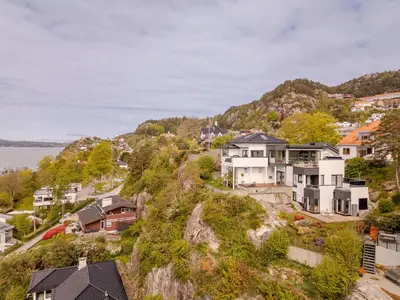 a group of houses on a hill next to the water at Panoramic view with private terrace in Bergen
