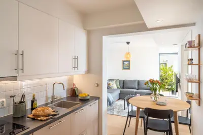 a kitchen and living room with a table and a couch at Panoramic view with private terrace in Bergen