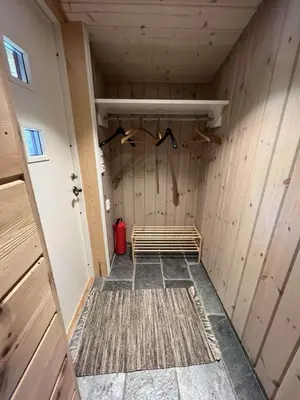 a small room with a bed in a wooden wall at Gamlestova in Viksdalen