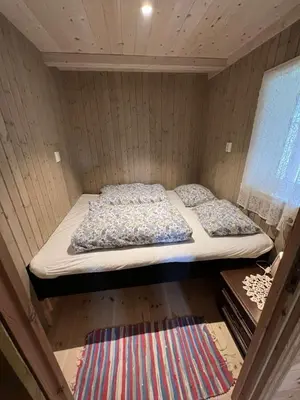 a bed in a small room with two pillows at Gamlestova in Viksdalen