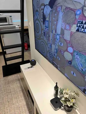 a room with a table with a tv on a wall at Cozy and modern studio house in Trondheim