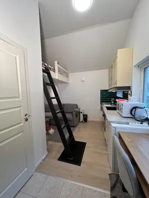 a kitchen with a ladder in the middle of a room at Cozy and modern studio house in Trondheim