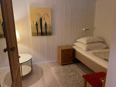 a small bedroom with a bed and a table at Sokkelleilighet med 3 soverom in Molde