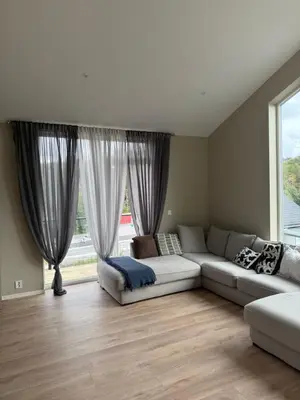 a living room with a couch and a large window at New Modern House by the Sea in Askøy