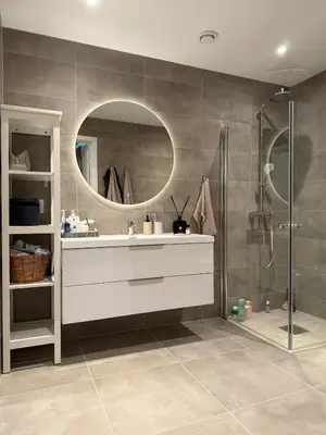 a bathroom with a sink and a shower with a mirror at New Modern House by the Sea in Askøy