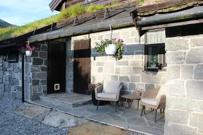 a stone house with two chairs and a table at Idyllic house with views - close to nature in Nydalen