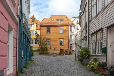 an alley in a city with a yellow house at Cosy flat in historical lane in Bergen
