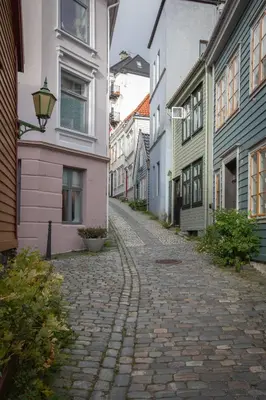 a cobblestone street in a city with buildings at Cosy flat in historical lane in Bergen