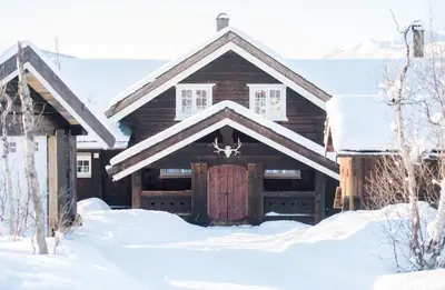 a log cabin with a garage in the snow at Family Cabin For Many In The High Mountains in Hovet