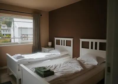two white beds in a bedroom with a window at Newly renovated apartment in beautiful Haramsøy in Ålesund