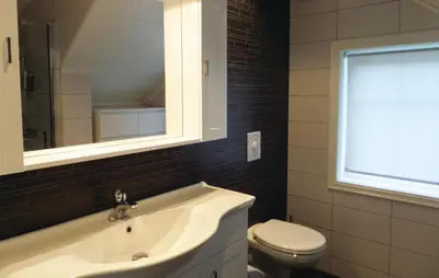 a bathroom with a sink and a toilet at Cozy Apartment In Fitjar in Fitjar