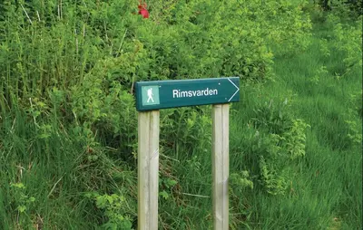 a blue street sign on two wooden poles at Cozy Apartment In Fitjar in Fitjar