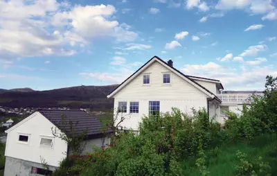 a white house sitting on top of a hill at Cozy Apartment In Fitjar in Fitjar