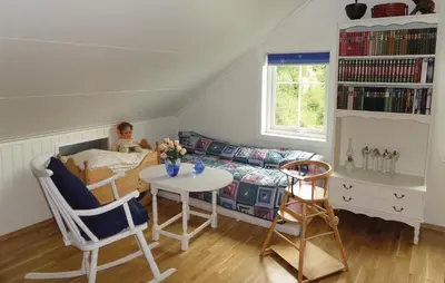 a little girl sitting in a bed in a room at Cozy Apartment In Fitjar in Fitjar