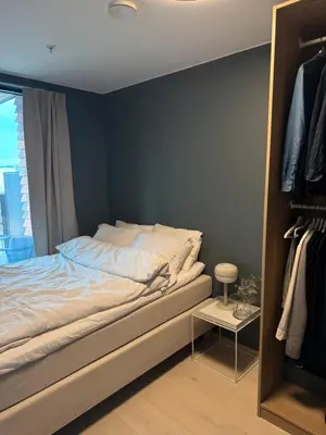 a bedroom with a bed and a blue wall at LADE - leilighet i Ringve Pluss in Trondheim