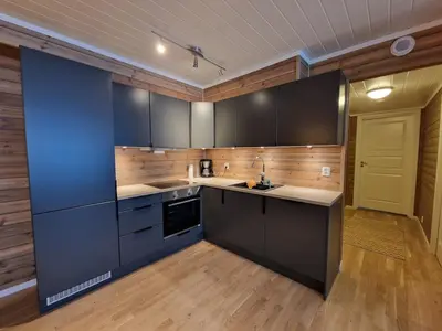 a large kitchen with black cabinets and a yellow door at Apartment in Voss - Tråstølen in Skulestadmo