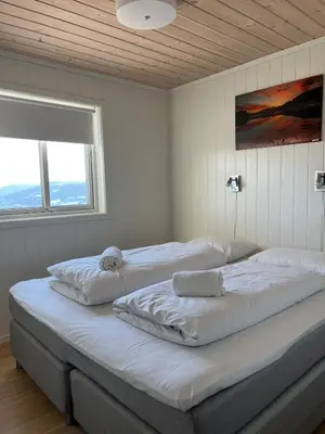 a bedroom with two beds with white sheets and a window at Mountain Sauna Lodge - Private Sunset Deck in Vossevangen