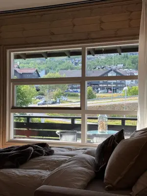 a large window in a bedroom with a large bed at Geiloholtet central city apartment in Geilo