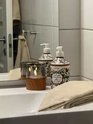 a bathroom with two bottles of soap and a mirror at Geiloholtet central city apartment in Geilo