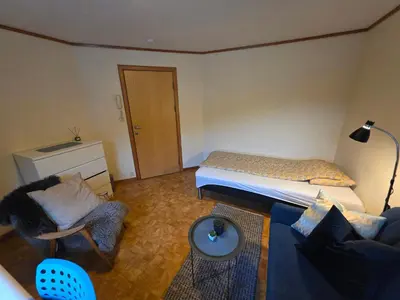 a room with a bed and a couch and a chair at Rom 3 i bufellesskap in Sogndal