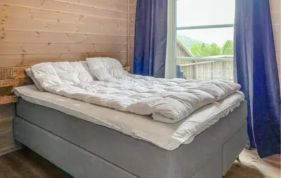 an unmade bed in a room with a window at Cozy Home In Hornindal With Sauna in Hornindal