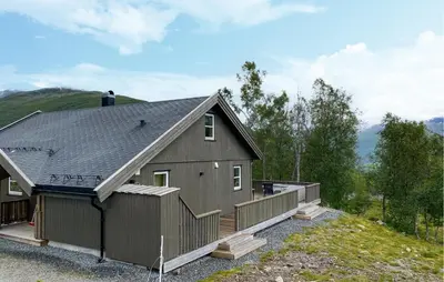 a house with a gambrel roof with a deck at Cozy Home In Hornindal With Sauna in Hornindal