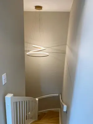 a hallway with a staircase with a light fixture at Familyhome for 8 people - 4 bedrooms - 10min from Bergen city center in Bergen